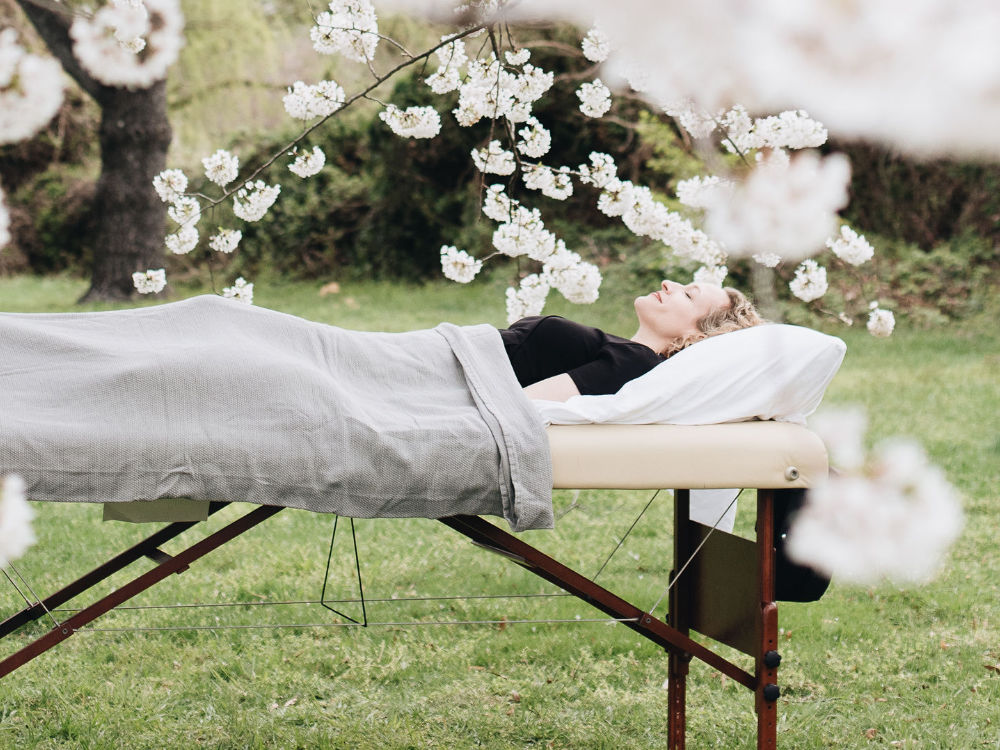 Insomnia patient on treatment table in field of cherry blossoms
