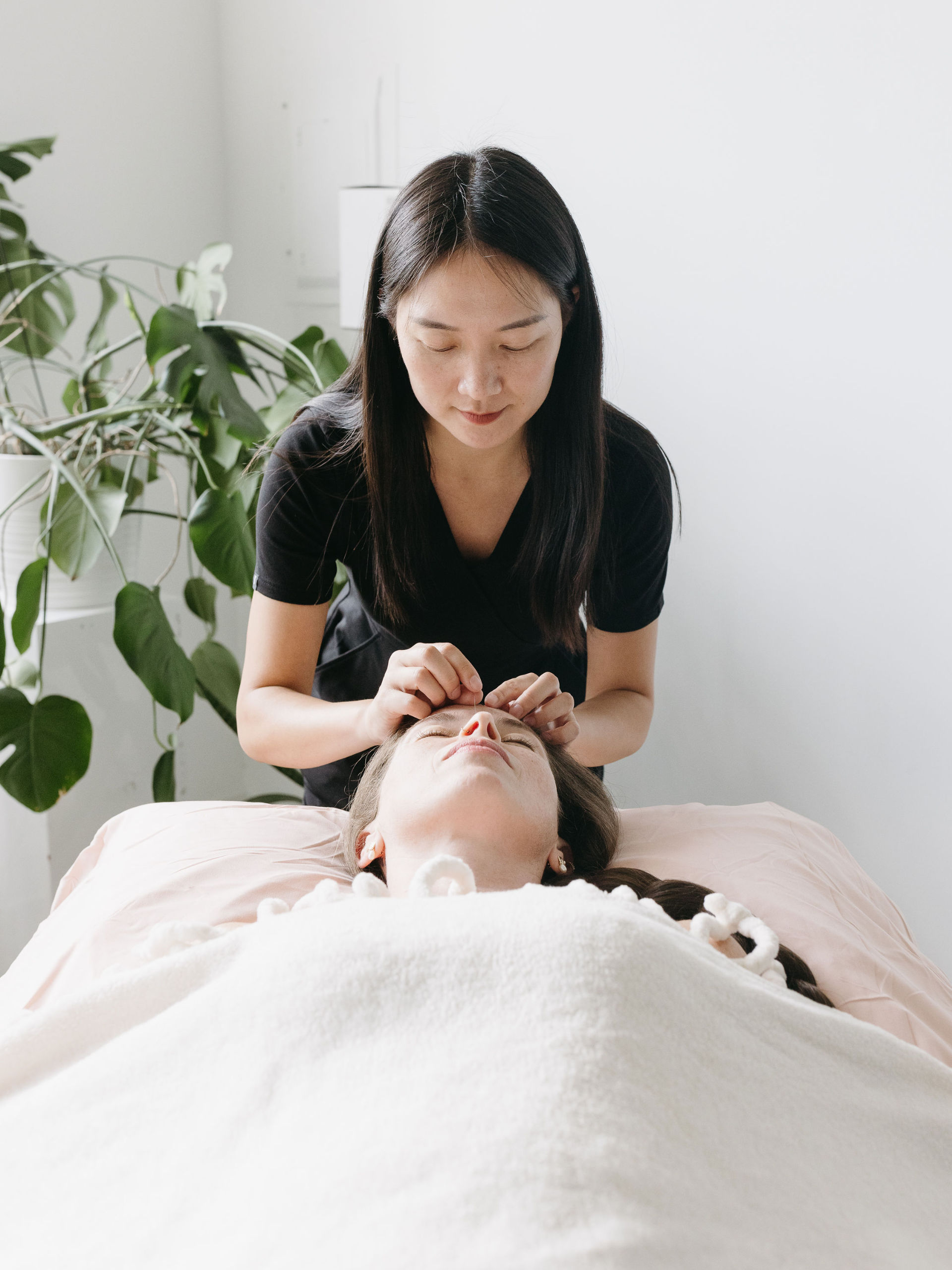 Cherry Blossom Healing Arts Acupuncture Treatment Women laying on her back receiving treatment at Cherry Blossom Healing Arts