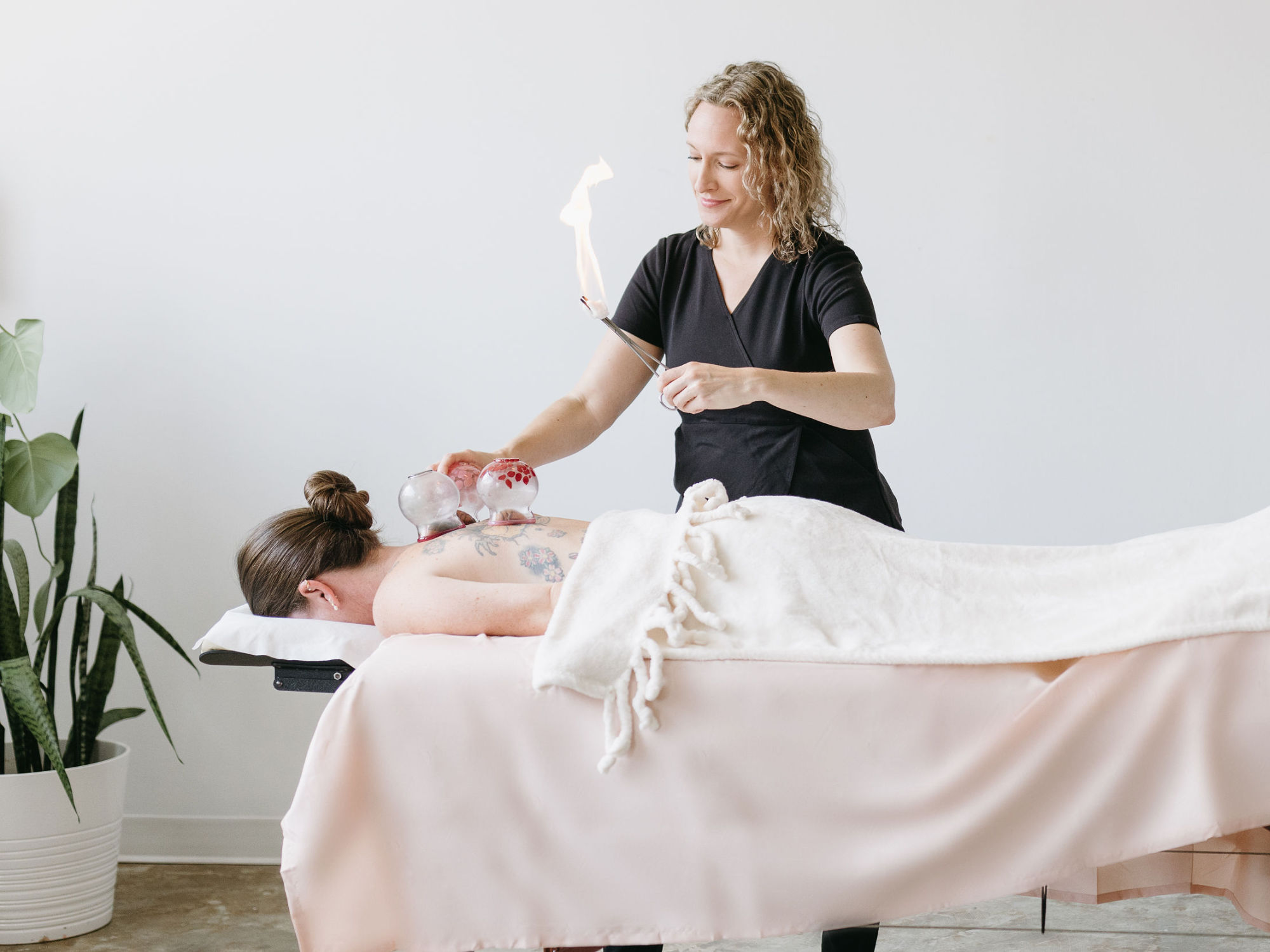 Cupping Therapy at Cherry Blossom Healing Arts Acupuncturist at Cherry Blossom Healing Arts giving a cupping therapy treatment to a women laying face down