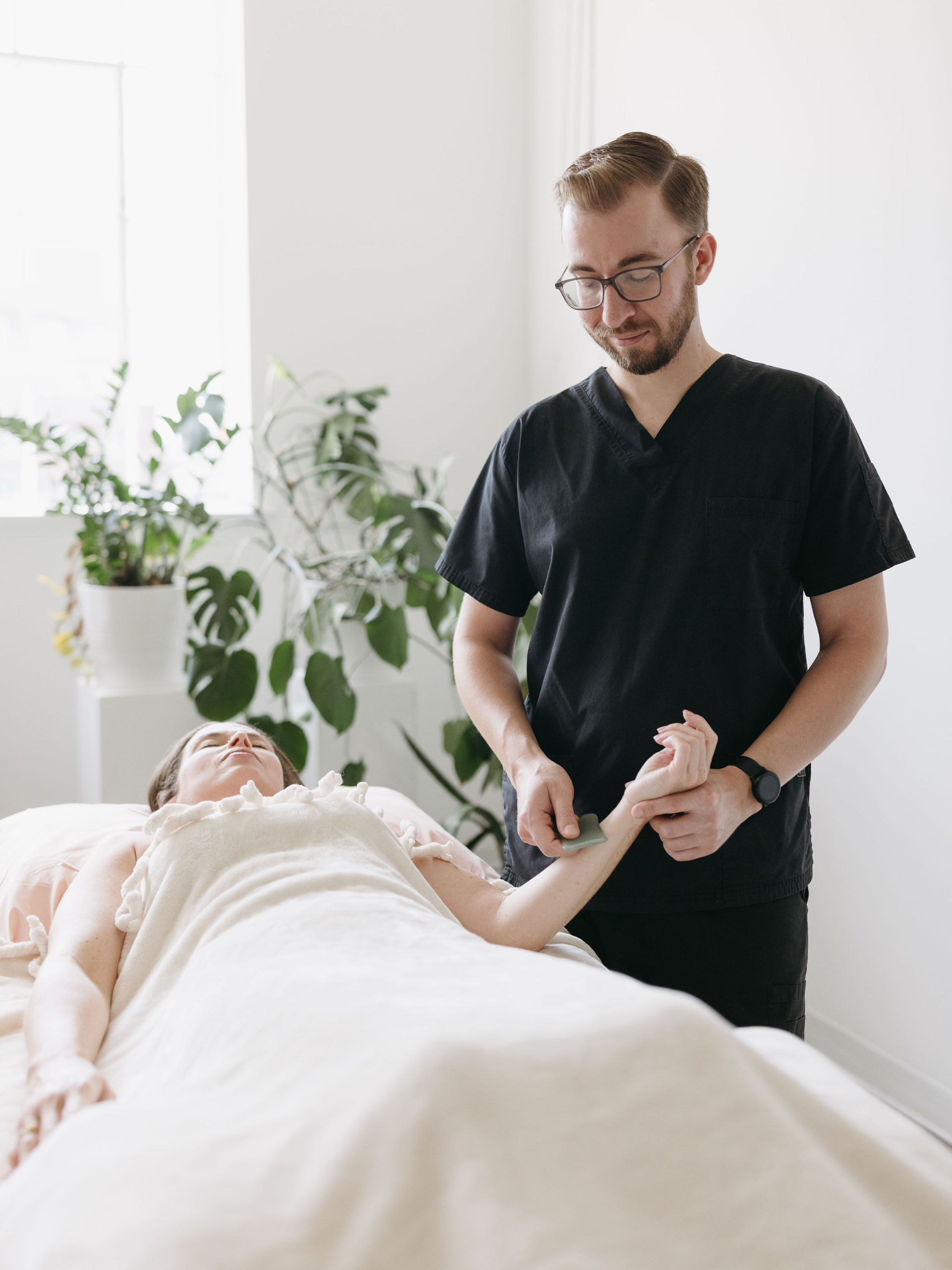 Gua Sha Therapy at Cherry Blossom Healing Arts Cherry Blossom Healing Arts acupuncturist performing Gua Sha therapy on a women laying on her back